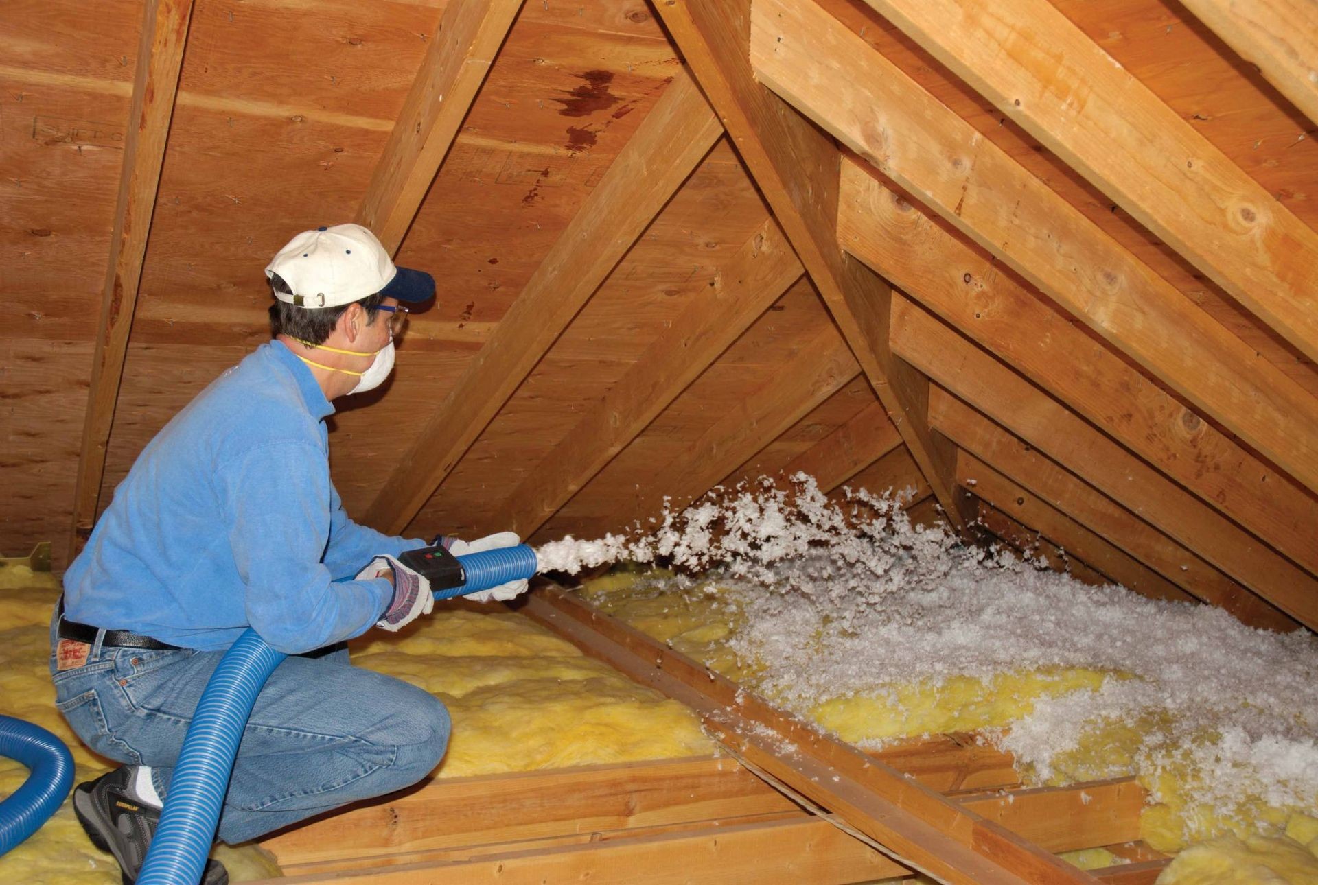 man installing attic insulation to improve energy efficiency
